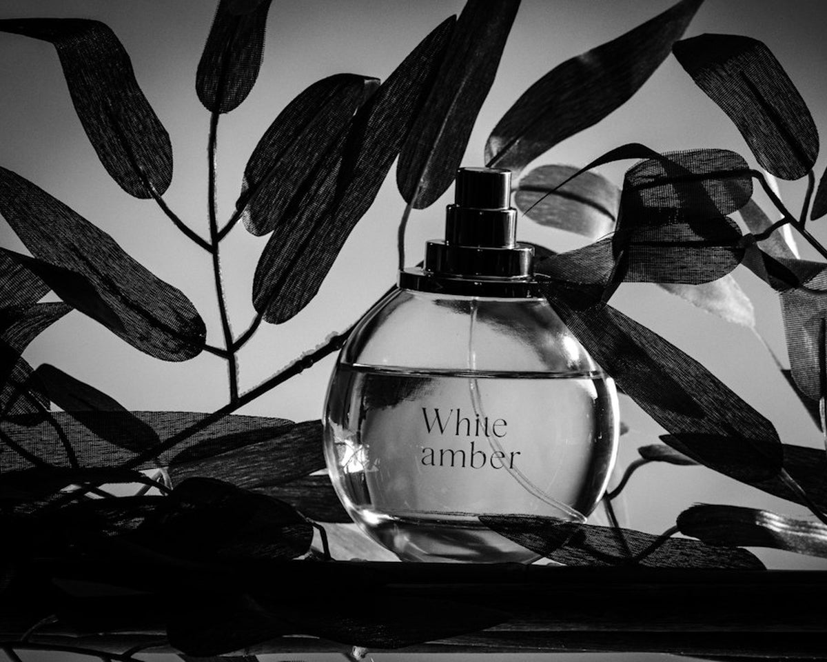 Perfume bottle among leaves